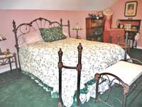 A charming room that features a queen sized antique-styled bed with a private bathroom and large shower.